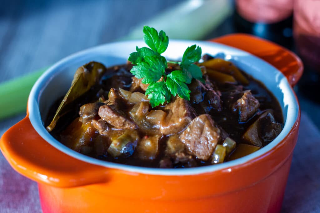Bowl of Slow Cooker Beef and Ale Stew with beer bottle