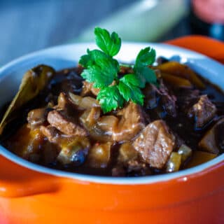 Bowl of Slow Cooker Beef and Ale Stew with beer bottle