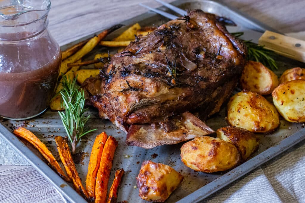 Slow cooked lamb shoulder on a roasting tray with vegetables and gravy