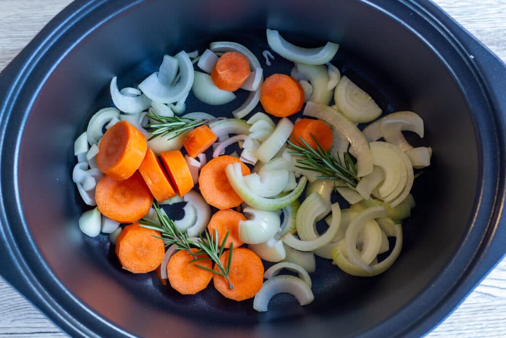 A bed of vegetables in the slow cooker