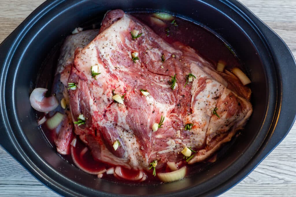 Lamb shoulder studded with garlic and rosemary, in the slow cooker