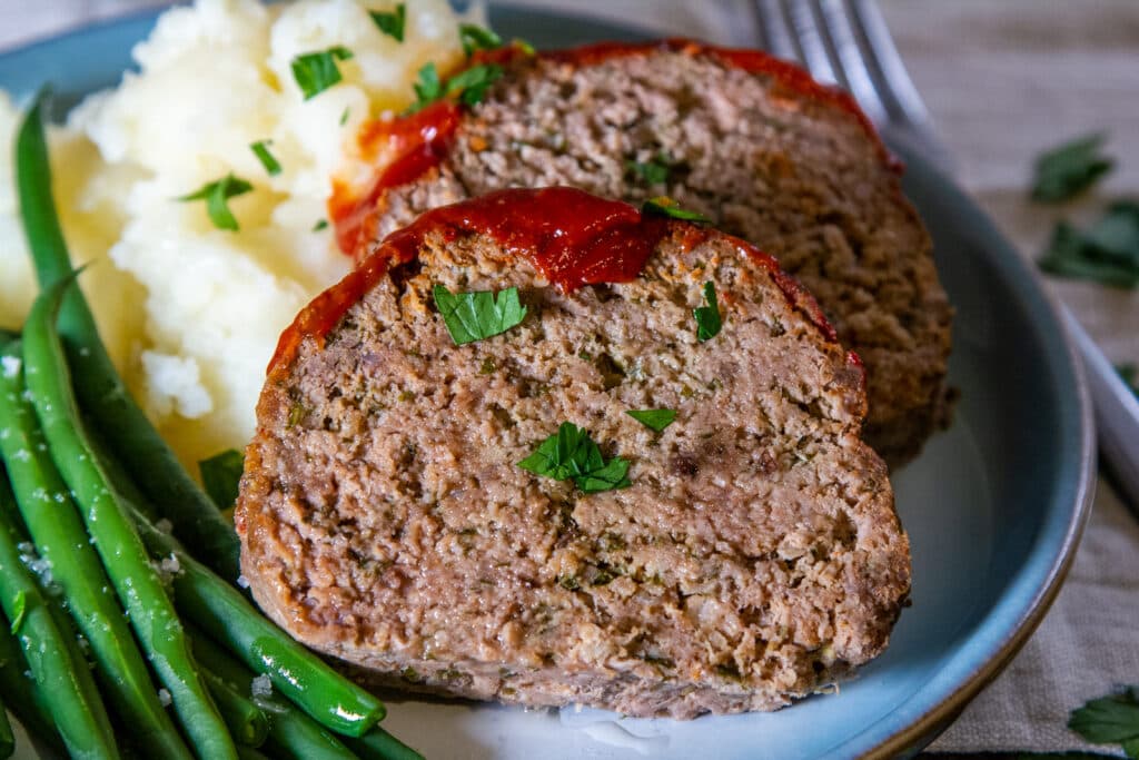 Sliced Meatloaf with mashed potato and vegetables.