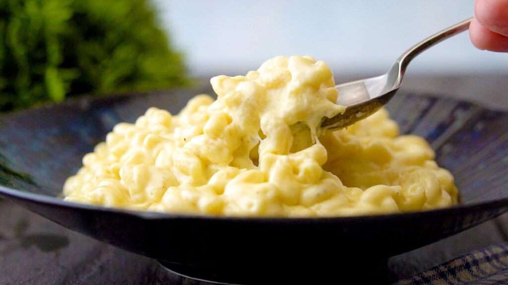 Close up view of Slow Cooker Macaroni Cheese on a plate with a fork