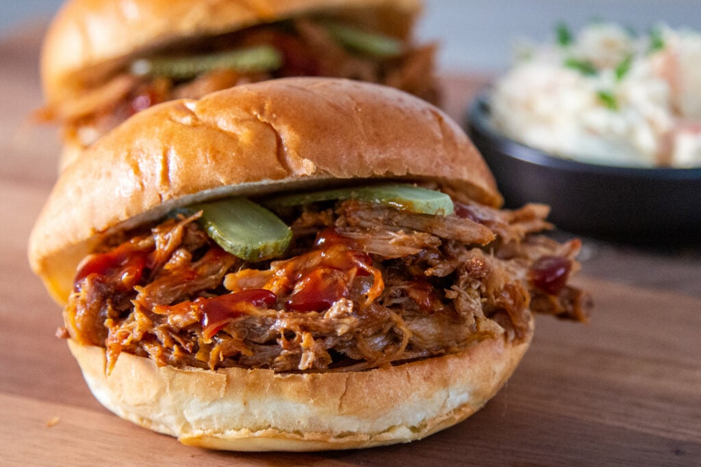 Slow cooked pulled pork in a brioche bun with pickles and coleslaw.