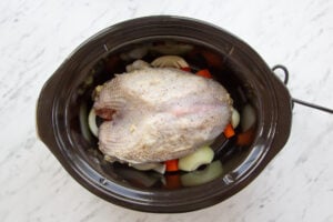 Image of Slow Cooker Turkey Crown on a bed of vegetables ready to cook.