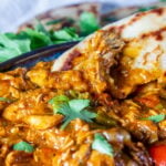 Slow Cooker Turkey Curry in a bowl with naan bread.