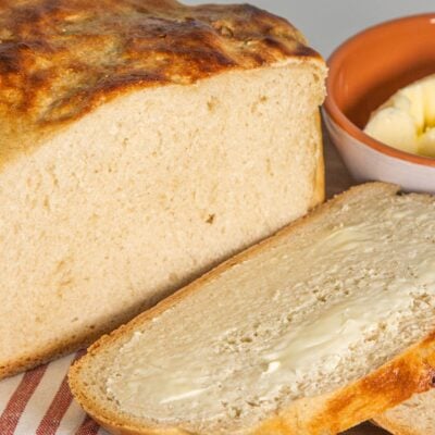 Slow Cooker white bread loaf sliced and buttered.