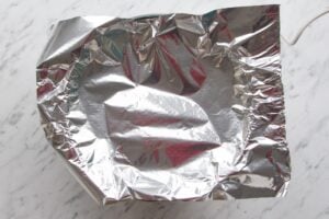Picture to show how to measure the amount of foil required to line a slow cooker to bake a cake.